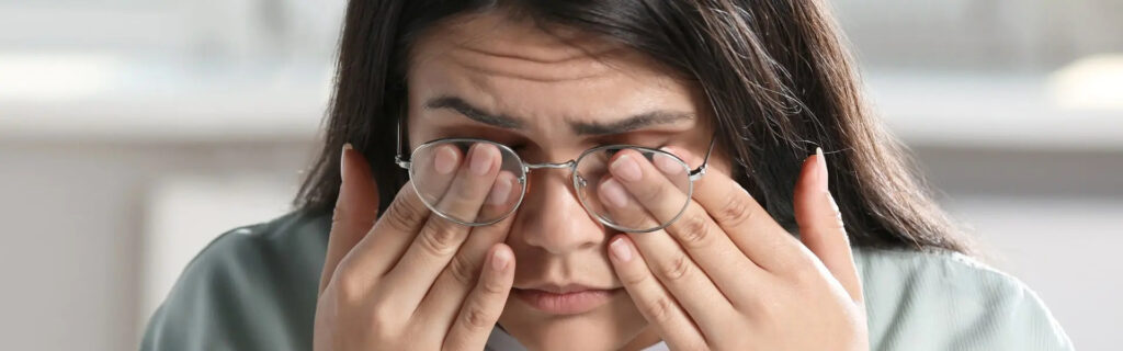 girl rubbing her eyes due to prologed computer use